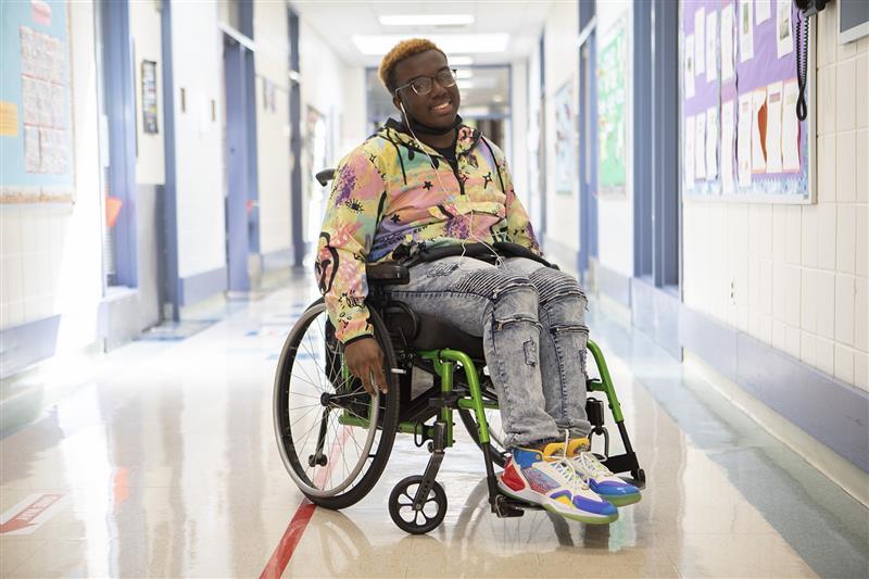 Disabled teen with colorful outfit in his wheelchair